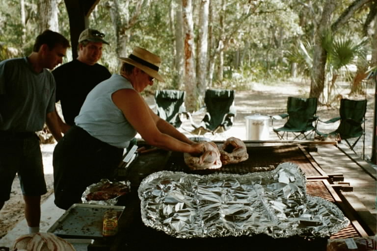 Rich and Ron coach Spyke as she moves a turkey to make room for the wild boar wrapped in aluminum foil